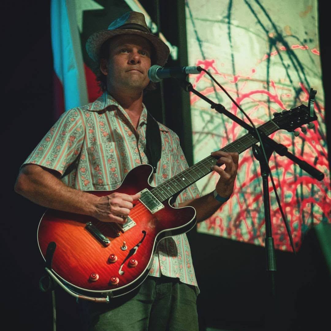 Guitarist with a semi-hollow electric on a festival stage
