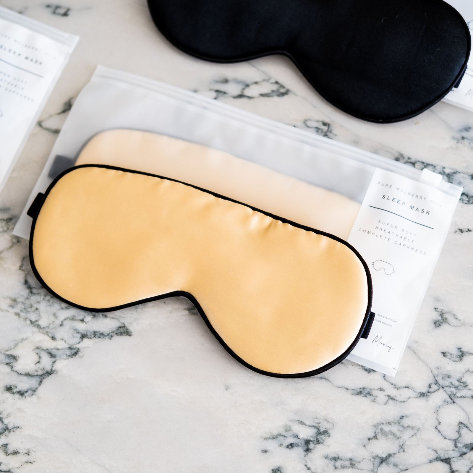 Silk sleep mask product flat lay on marble